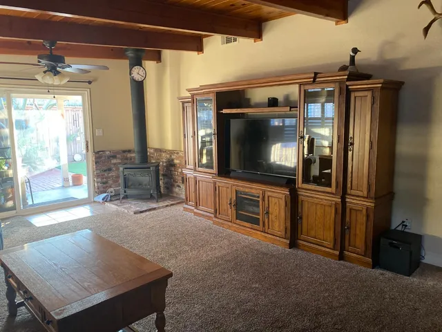 a living room with stainless steel appliances furniture a rug and a view of kitchen