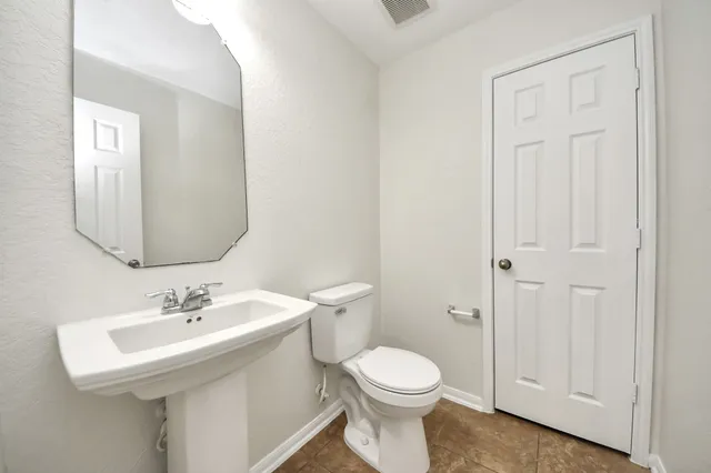 a bathroom with a toilet a sink and a mirror