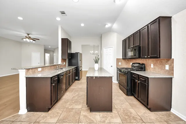 a large kitchen with stainless steel appliances lots of counter top space