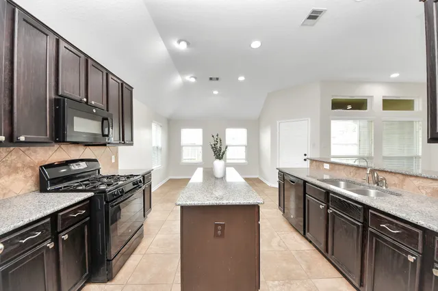 a kitchen with stainless steel appliances granite countertop a sink stove and cabinets