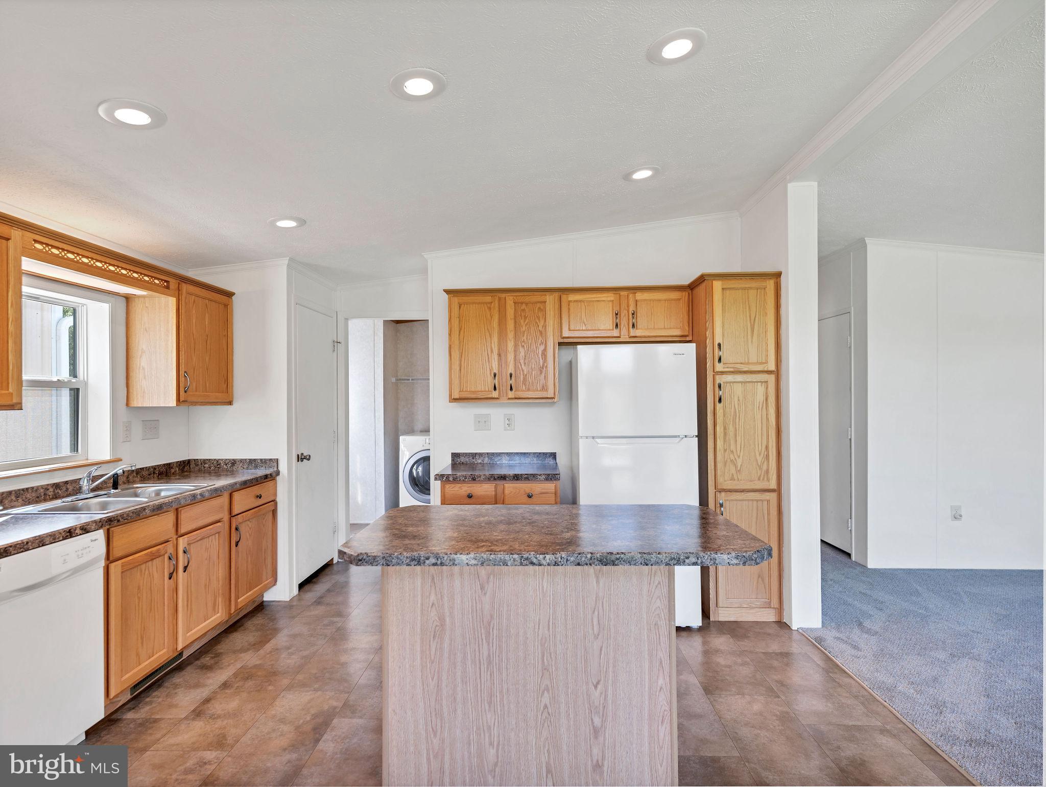 9811 Peerless Road Bishopville, MD 21813 - Photo 12 of 66 a view of a kitchen with kitchen island granite countertop a large window and a sink