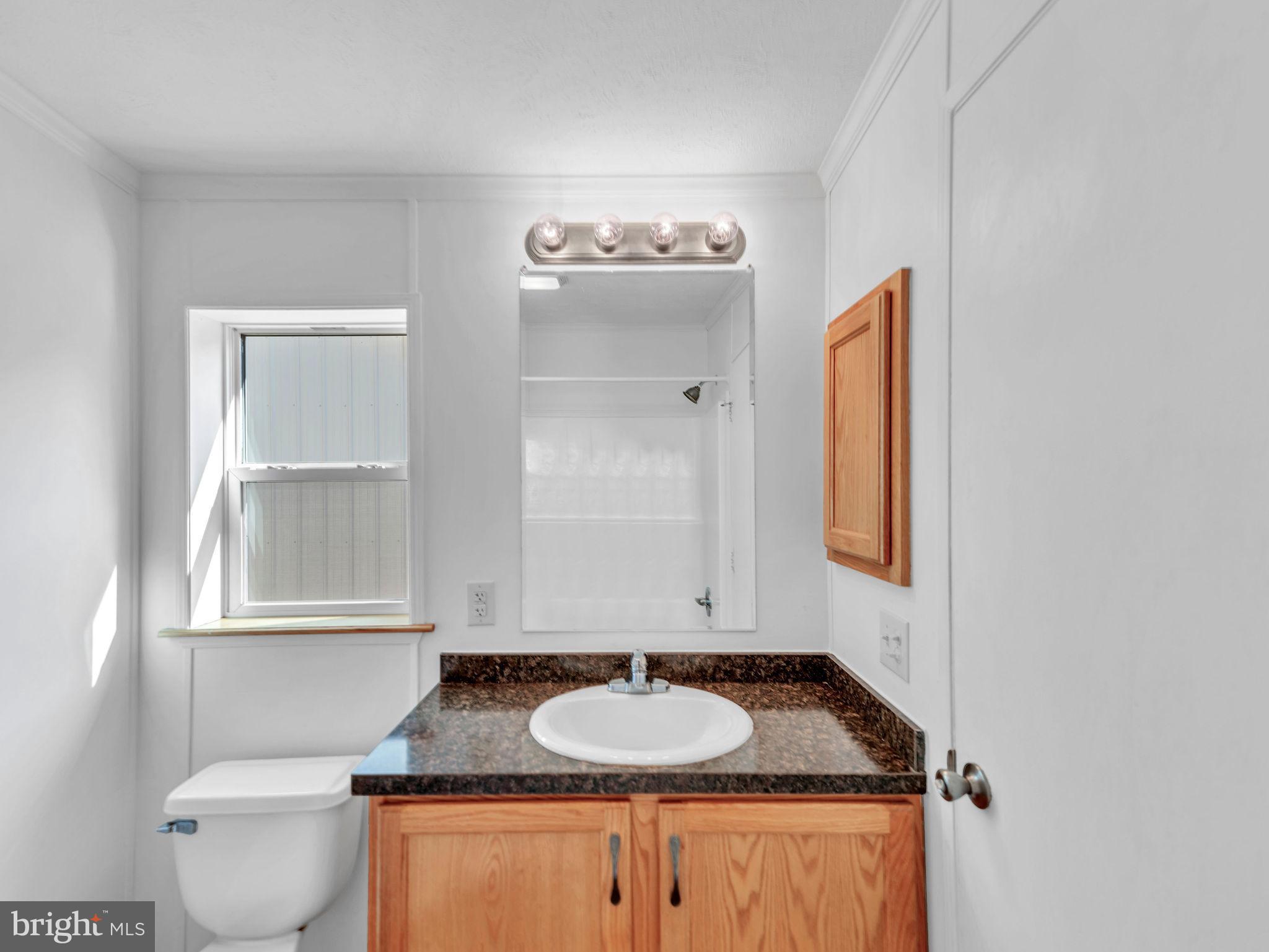 9811 Peerless Road Bishopville, MD 21813 - Photo 27 of 66 a bathroom with a granite countertop sink and a mirror