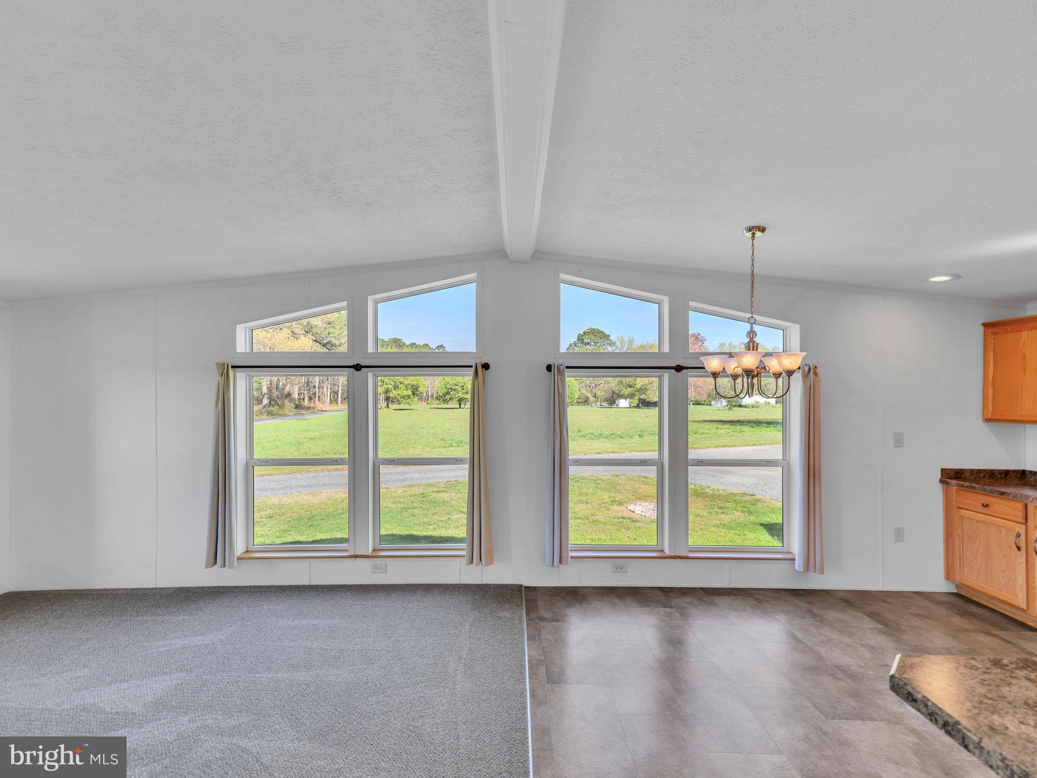 9811 Peerless Road Bishopville, MD 21813 - Photo 9 of 66 a view of an empty room with window and chandelier fan