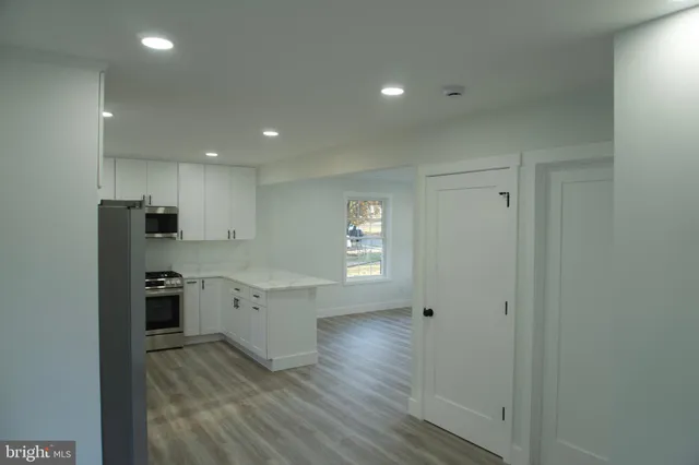 a kitchen with white cabinets and stainless steel appliances