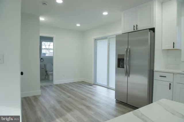 a view of a refrigerator in kitchen and wooden floor