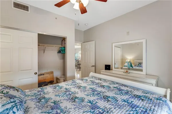 a bedroom with a bed and a chandelier fan