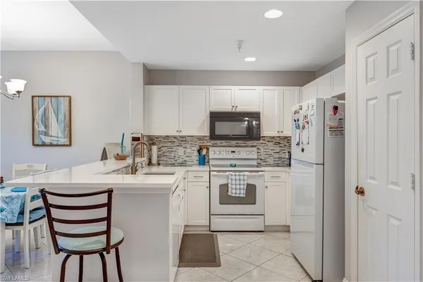 a kitchen with a sink appliances and cabinets
