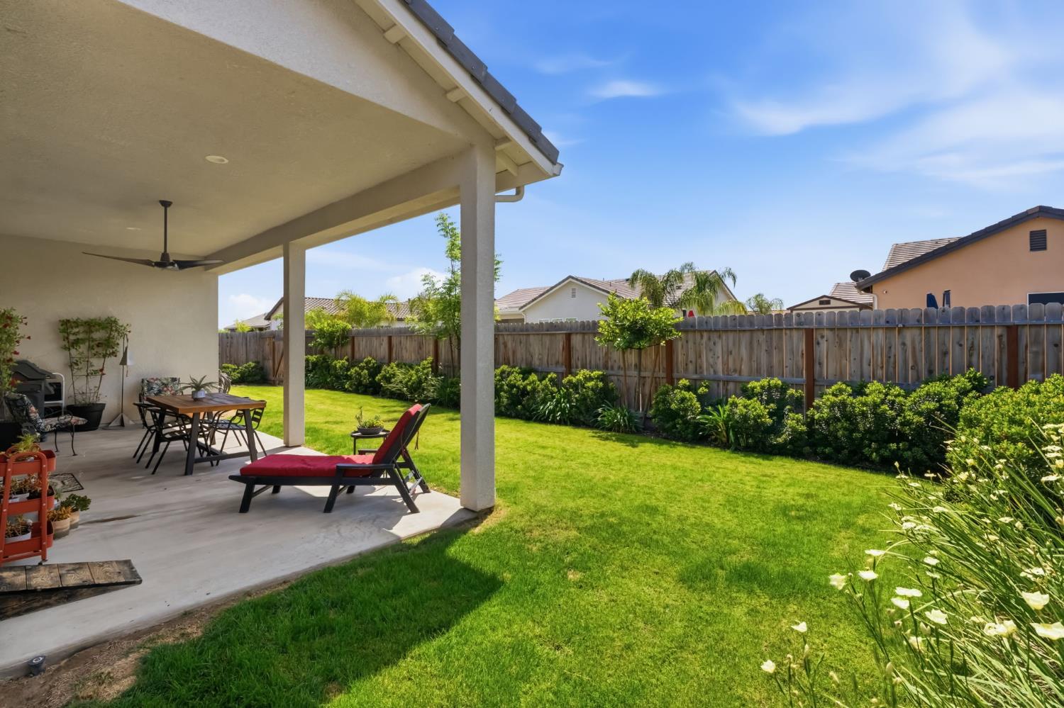 2100 Azalea Street Kingsburg, CA 93631 - Photo 32 of 54 a view of a patio with table and chairs potted plants and a palm tree