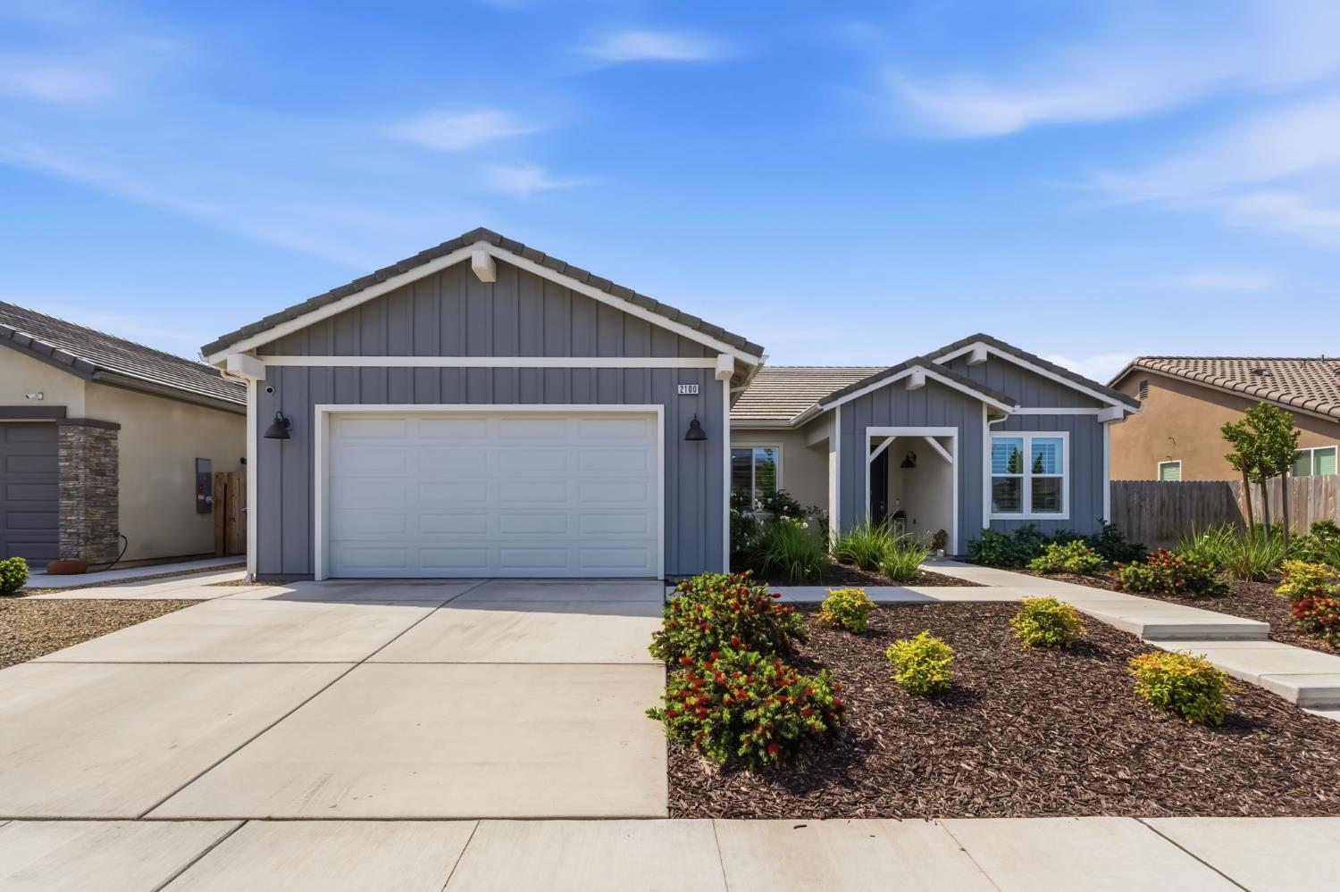 2100 Azalea Street Kingsburg, CA 93631 - Photo 35 of 54 a front view of a house with a yard and garage