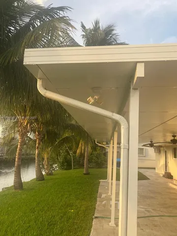 a view of swimming pool with a table and chairs under palm trees