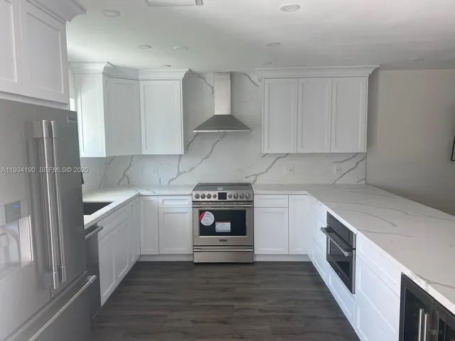a kitchen with stainless steel appliances granite countertop a stove and a refrigerator