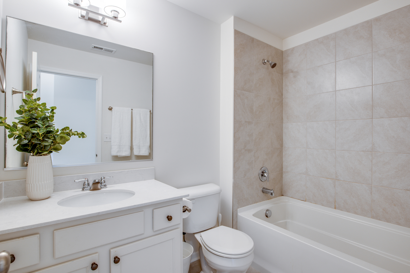 4477 Monroe Court Naperville, IL 60564 - Photo 17 of 23 a bathroom with a sink a mirror a bathtub and shower