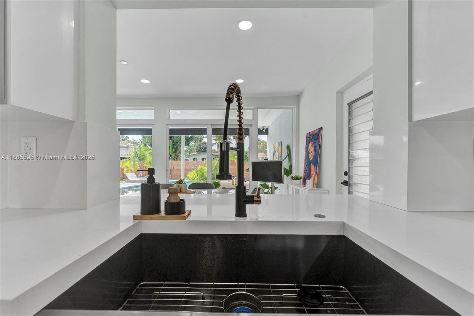 1446 Scott Street Hollywood, FL 33020 - Photo 13 of 47 a kitchen with a sink and chandelier