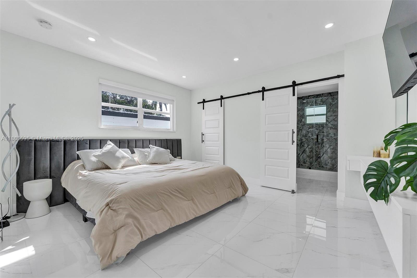 1446 Scott Street Hollywood, FL 33020 - Photo 18 of 47 a spacious bedroom with a bed and a potted plant