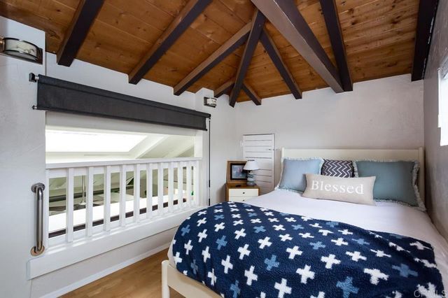 a bedroom with a bed and a flat tv screen on wall