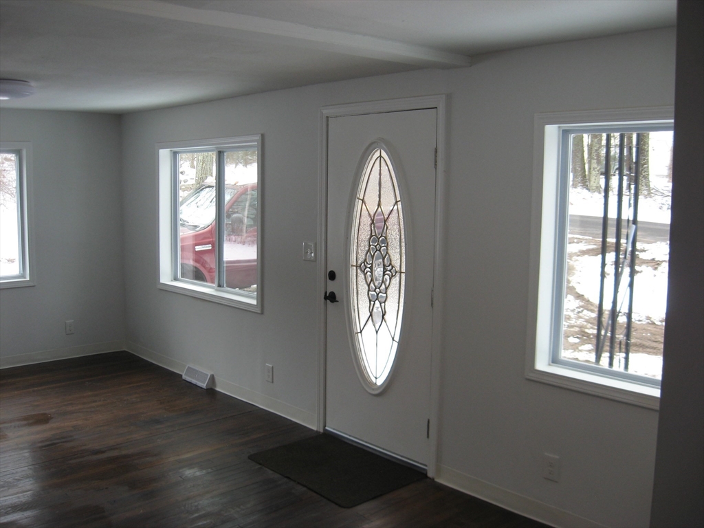 160 Peterson Road Palmer, MA 01069 - Photo 8 of 24 an empty room with wooden floor windows and entryway
