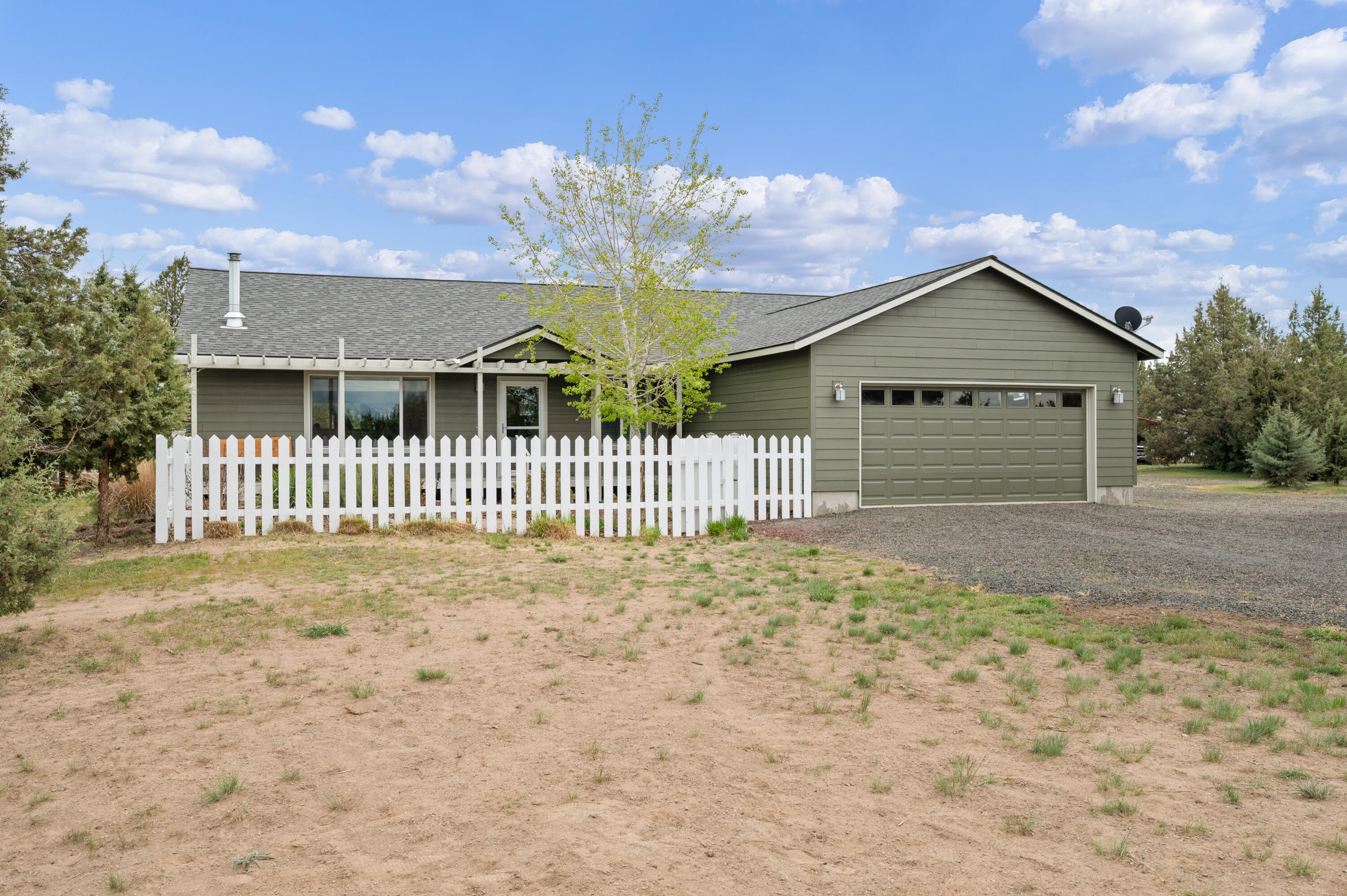 16625 Southwest Dove Road Terrebonne, OR 97760 - Photo 3 of 50 a view of a brick house next to a yard with large trees