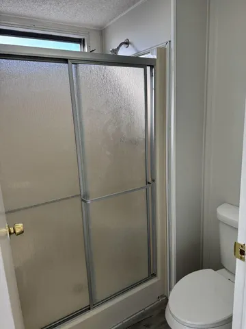 a bathroom with a white toilet and a shower curtain