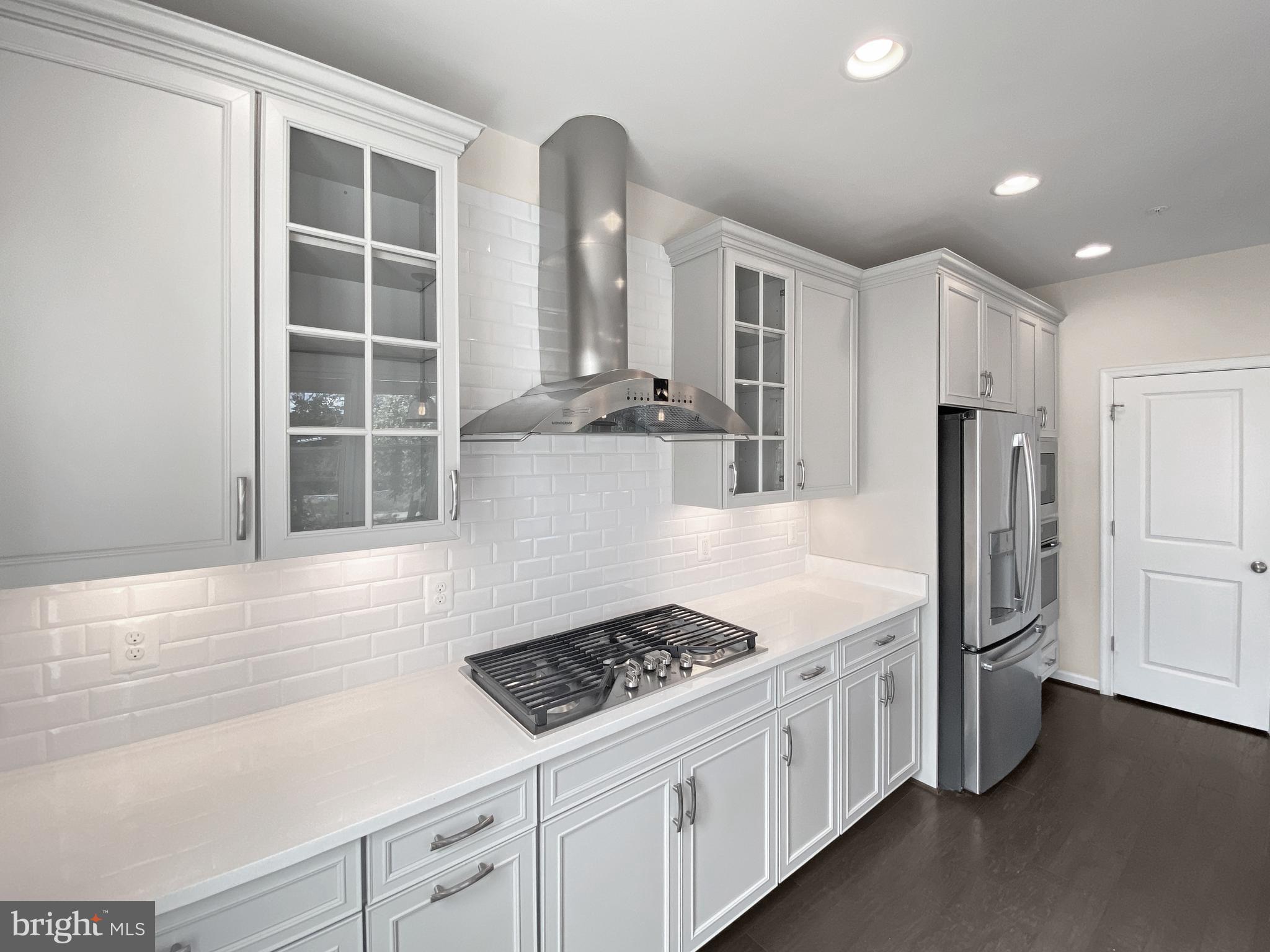 4967 Lakeside Crossing Chantilly, VA 20151 - Photo 18 of 45 a kitchen with stainless steel appliances kitchen island granite countertop a refrigerator and a sink