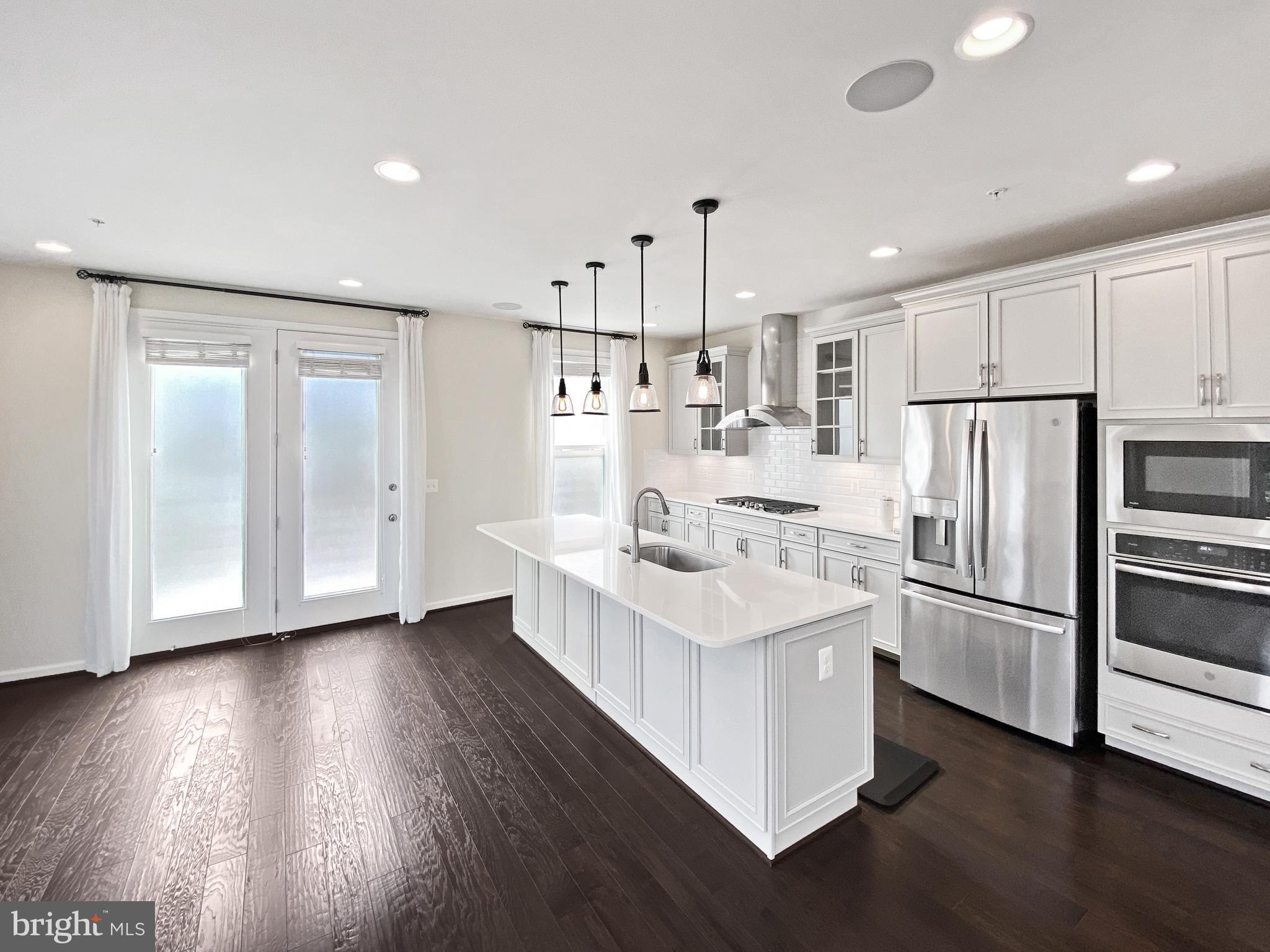 4967 Lakeside Crossing Chantilly, VA 20151 - Photo 2 of 45 a kitchen with kitchen island white cabinets and stainless steel appliances