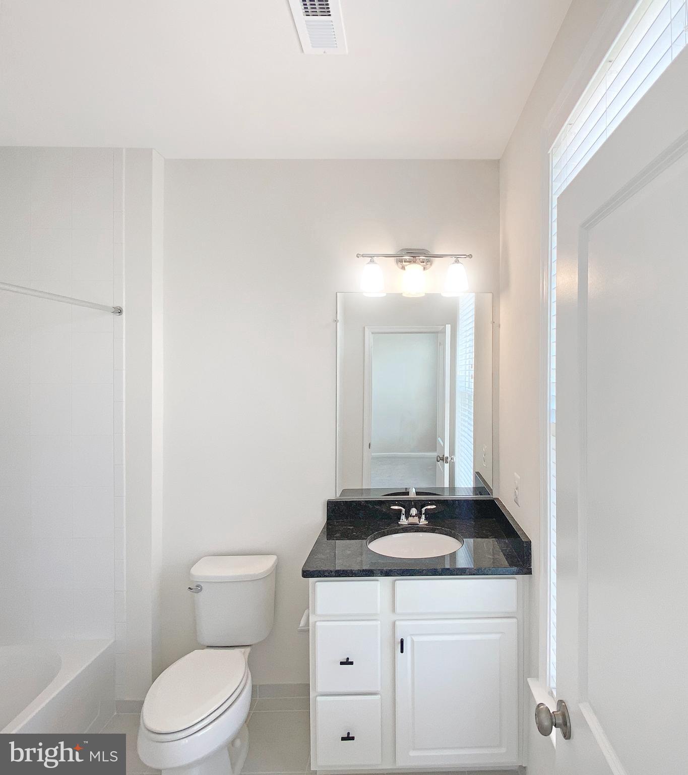 4967 Lakeside Crossing Chantilly, VA 20151 - Photo 29 of 45 a bathroom with a granite countertop sink a toilet and a mirror