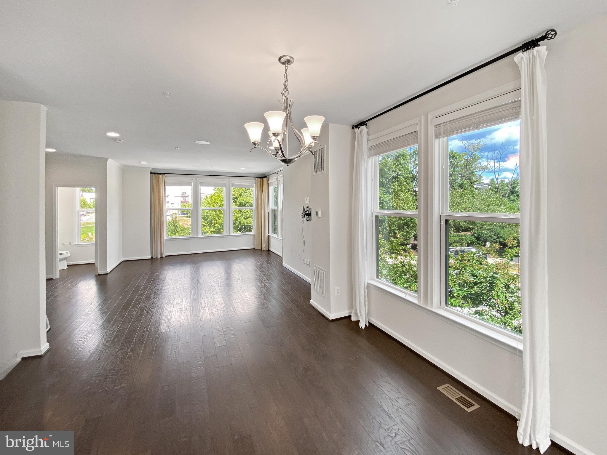 4967 Lakeside Crossing Chantilly, VA 20151 - Photo 5 of 45 a view of an empty room with wooden floor and a window