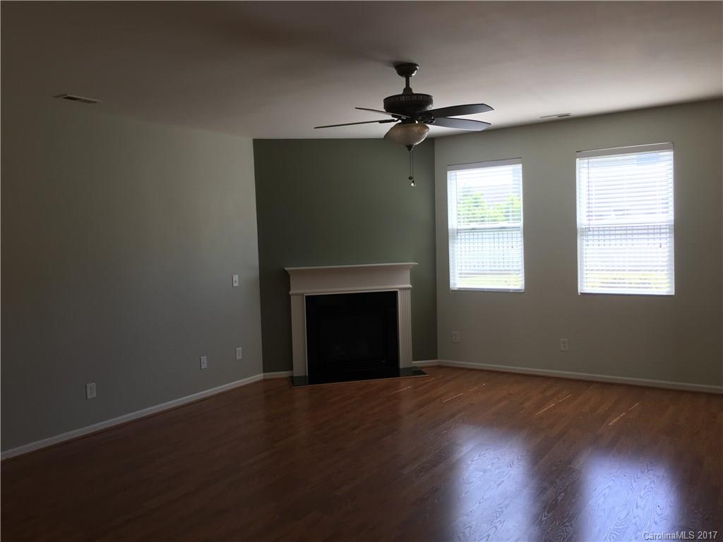 1011 Rural Farm Road Indian Trail, NC 28079 - Photo 4 of 24 a view of an empty room with wooden floor fireplace and a window