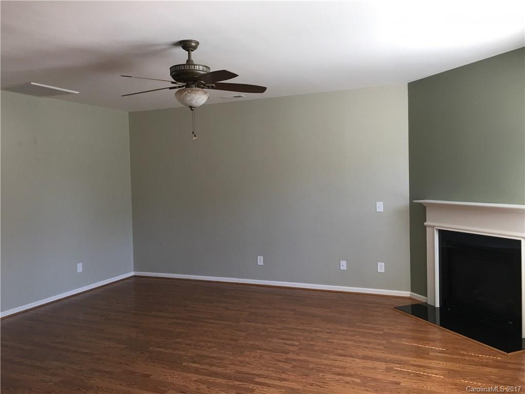 1011 Rural Farm Road Indian Trail, NC 28079 - Photo 5 of 24 a view of a room with wooden floor a fireplace and a window
