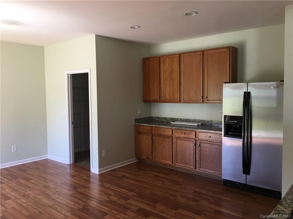 1011 Rural Farm Road Indian Trail, NC 28079 - Photo 6 of 24 a kitchen with granite countertop wooden floors a refrigerator and a stove