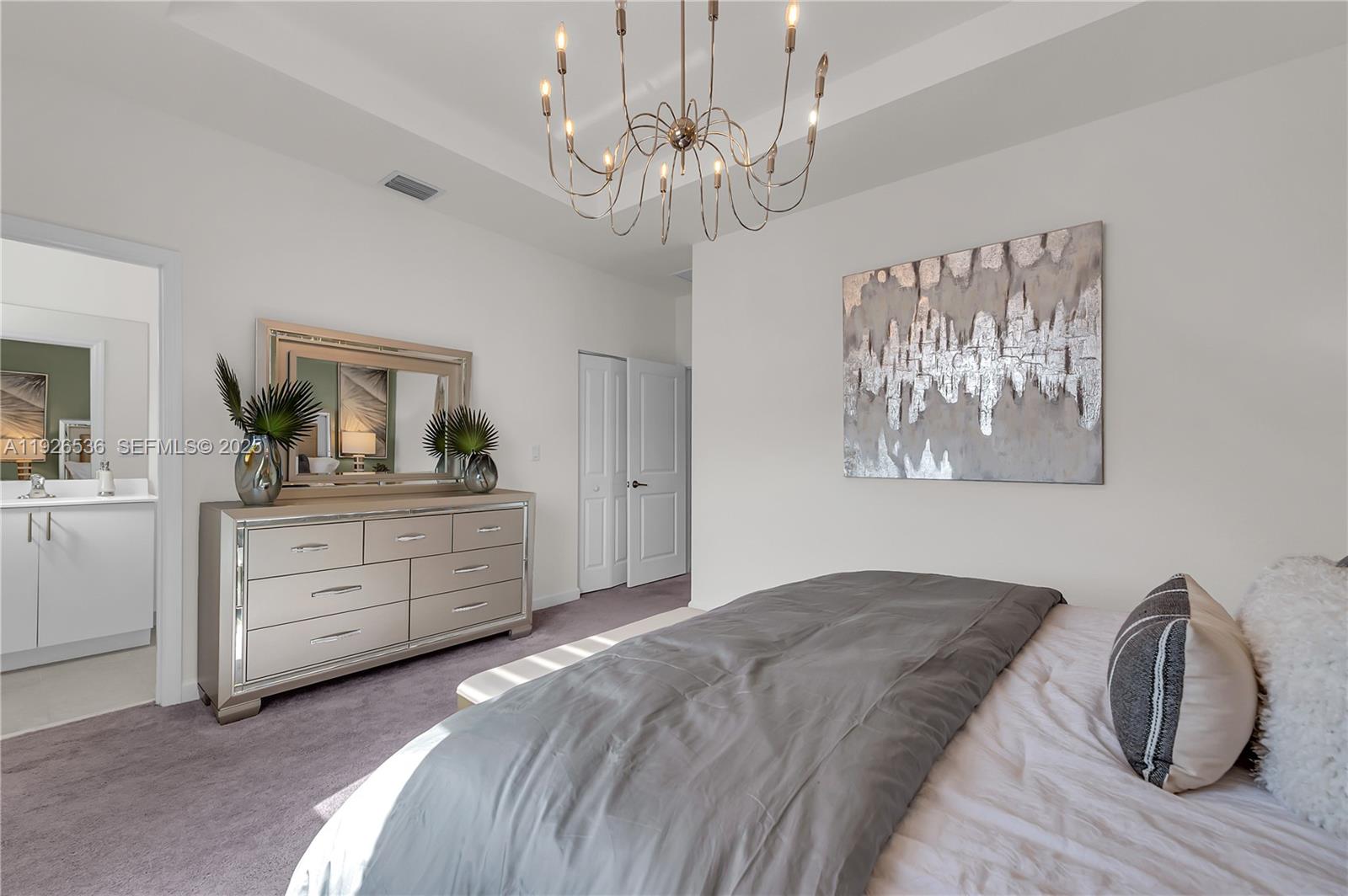 12980 Southwest 233rd Terrace Homestead, FL 33032 - Photo 19 of 28 a bedroom with a bed and a chandelier