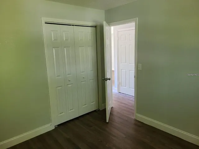 a view of a hallway with wooden floor and entryway