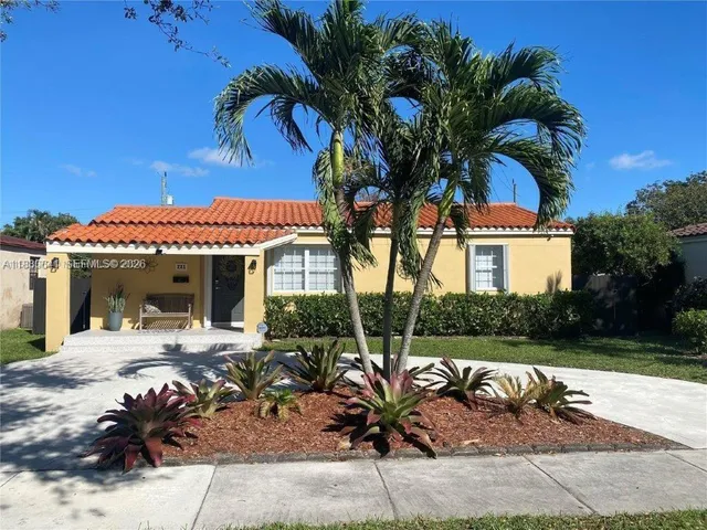 a view of a patio with table and chairs with a potted plants and palm trees