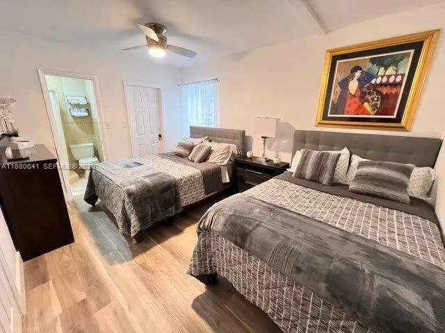 a bedroom with two beds and painting on the wall