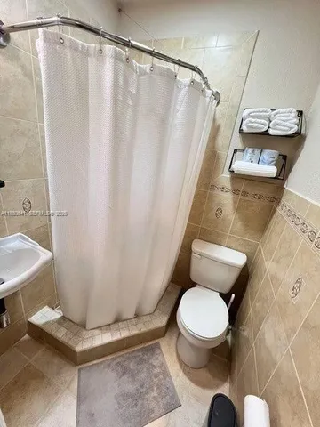 a white toilet sitting next to a shower curtain