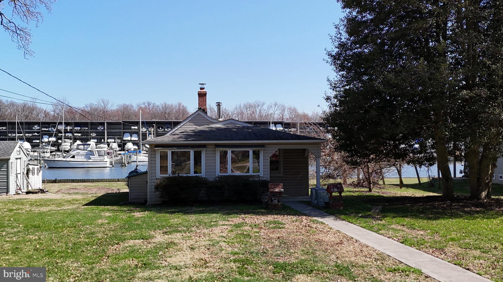 109 Hughes Shore Road Baltimore, MD 21220 - Photo 2 of 43 a front view of a house with a garden