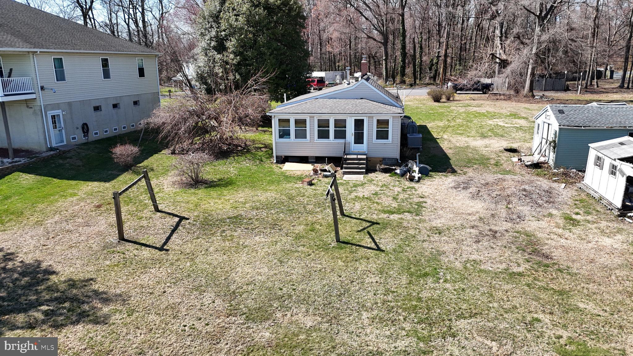 109 Hughes Shore Road Baltimore, MD 21220 - Photo 40 of 43 a table and chairs under an umbrella in front of house