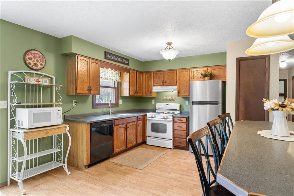 1010 Bonniebrook Road Butler, PA 16002 - Photo 15 of 48 a kitchen with stainless steel appliances granite countertop a refrigerator a stove a sink a dining table and chairs with wooden floor