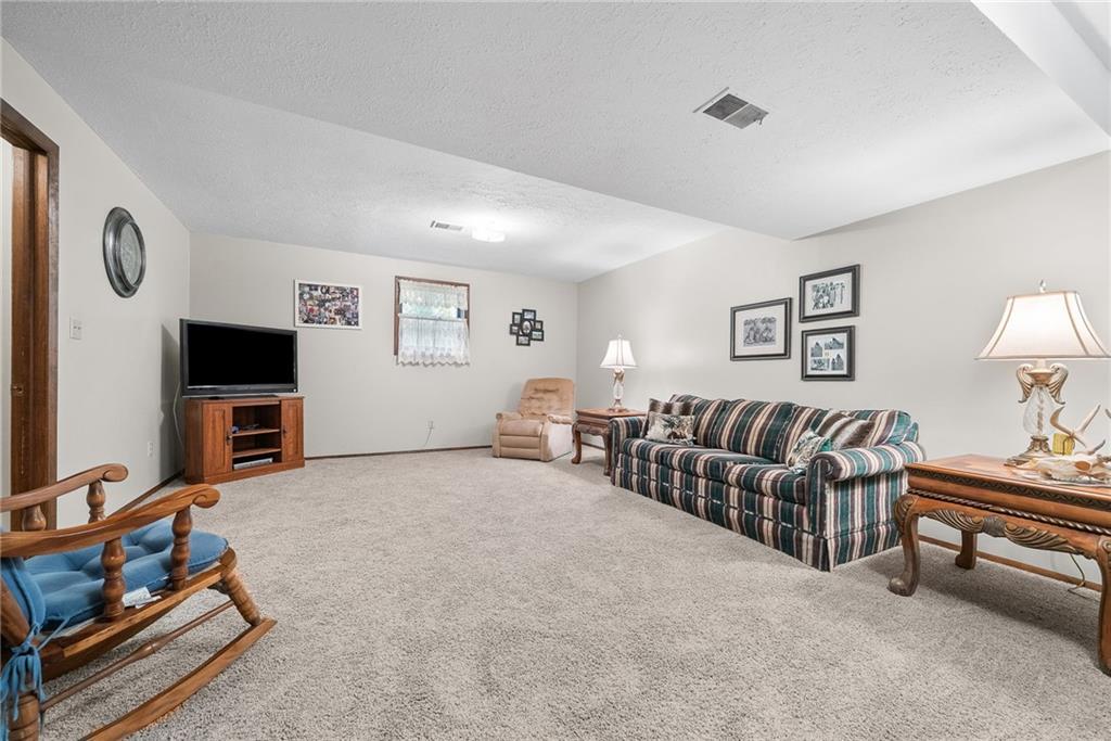 1010 Bonniebrook Road Butler, PA 16002 - Photo 31 of 48 a living room with furniture a flat screen tv and a lamp