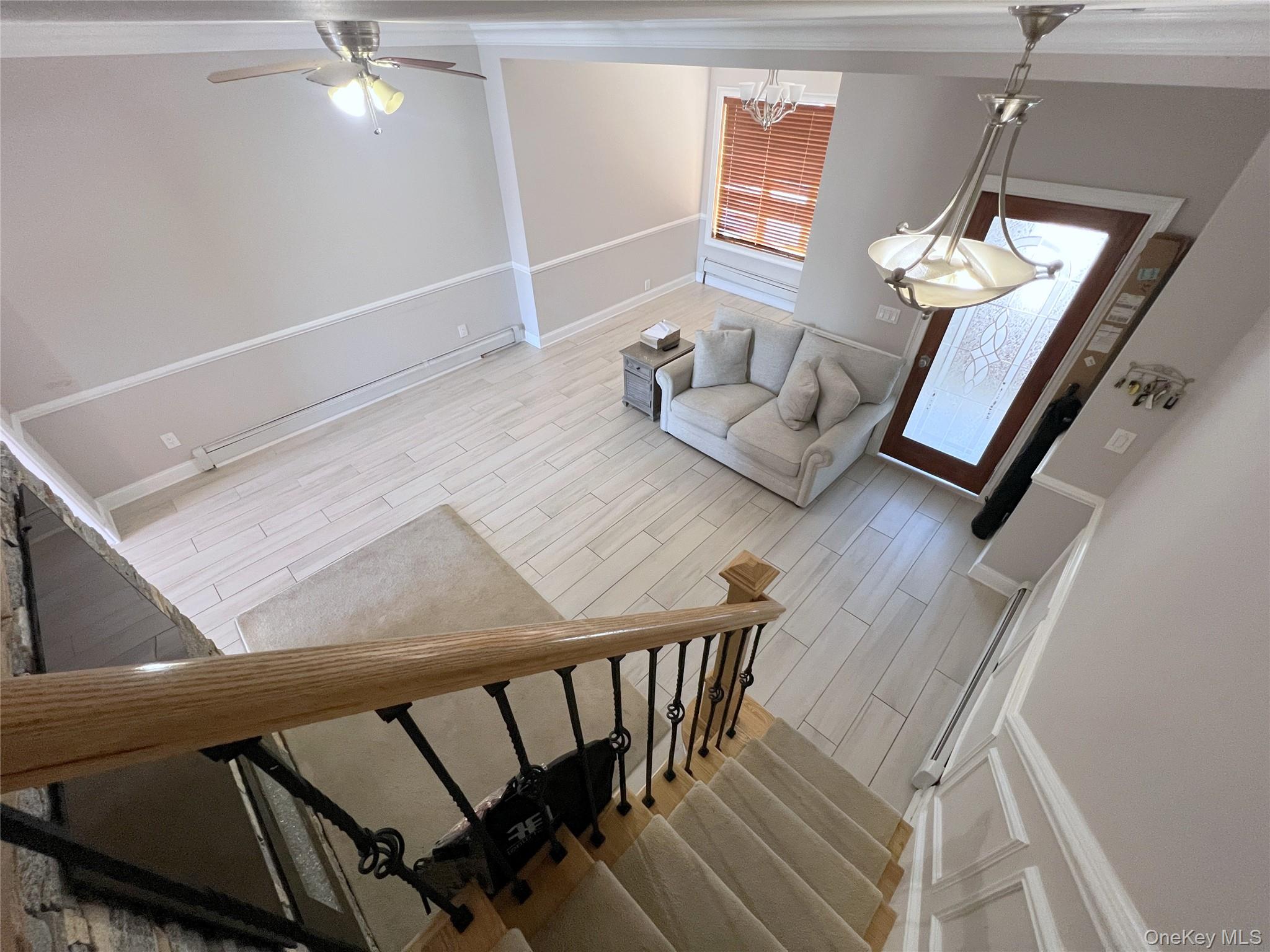 67-31 52nd Road Queens, NY 11378 - Photo 13 of 21 Staircase with wood finish floors, ceiling fan, and crown molding
