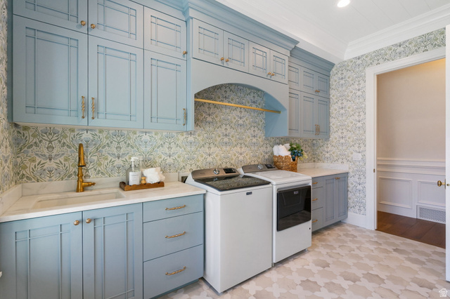 115 East Hidden Ridge Lane, Unit 42 Mapleton, UT 84664 - Photo 34 of 103 Laundry room featuring custom blue cabinetry, marble-look countertops, patterned wallpaper, a brass-finish faucet, and patterned floor tiling