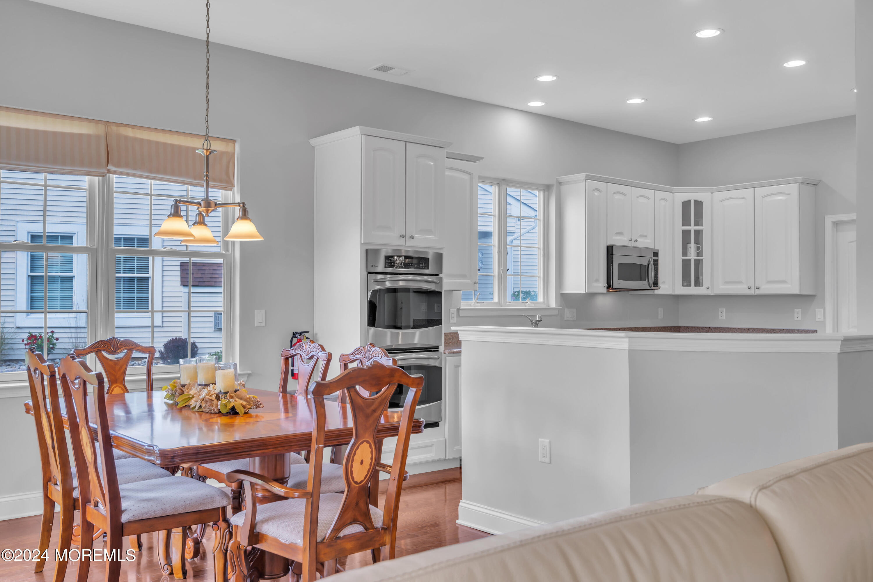 49 Eagleswood Drive Waretown, NJ 08758 - Photo 20 of 51 a kitchen with stainless steel appliances granite countertop a stove top oven a sink a dining table and chairs