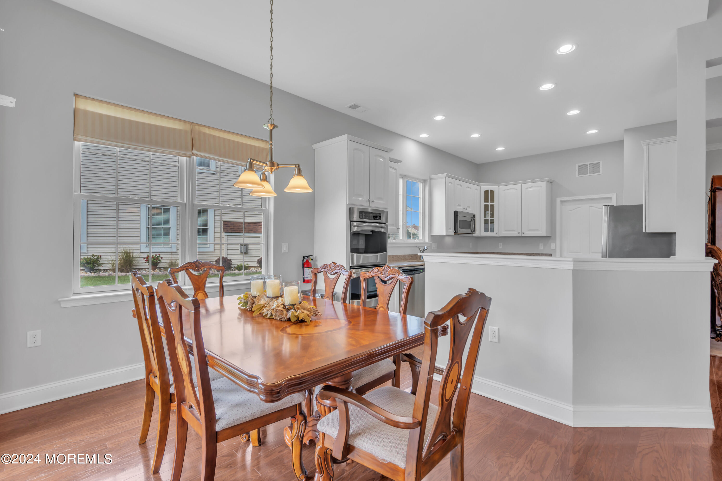 49 Eagleswood Drive Waretown, NJ 08758 - Photo 21 of 51 a dining room with stainless steel appliances kitchen island granite countertop a dining table chairs and a refrigerator