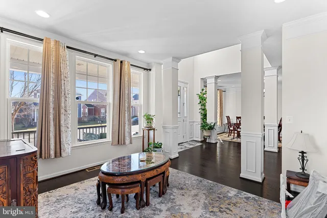 a view of a dining room with furniture a chandelier and wooden floor