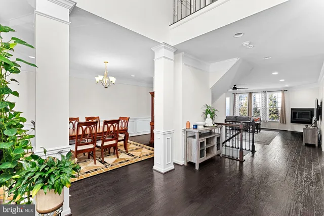 a view of a hallway with wooden floor and a living room