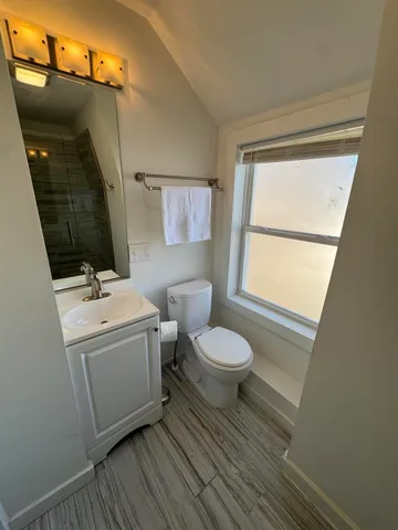 a bathroom with a toilet sink and mirror