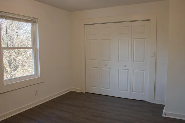 an empty room with wooden floor and sliding door