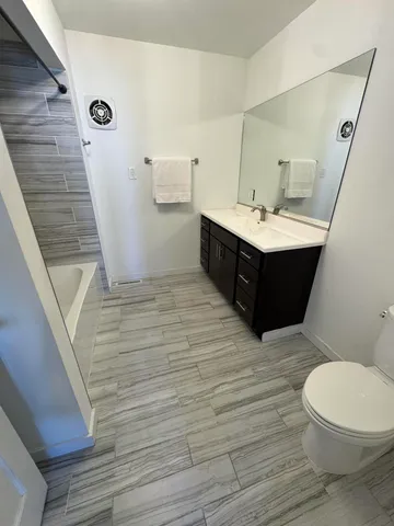 a bathroom with a sink vanity mirror and toilet