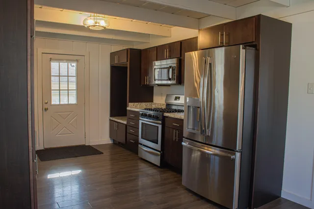 a kitchen with stainless steel appliances a refrigerator and a stove top oven