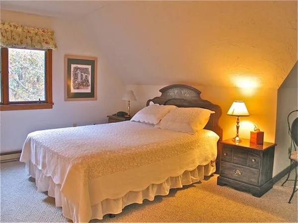 a bedroom with a bed and lamp with window