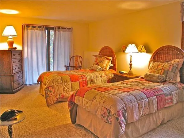 a bedroom with two beds and painting on the wall